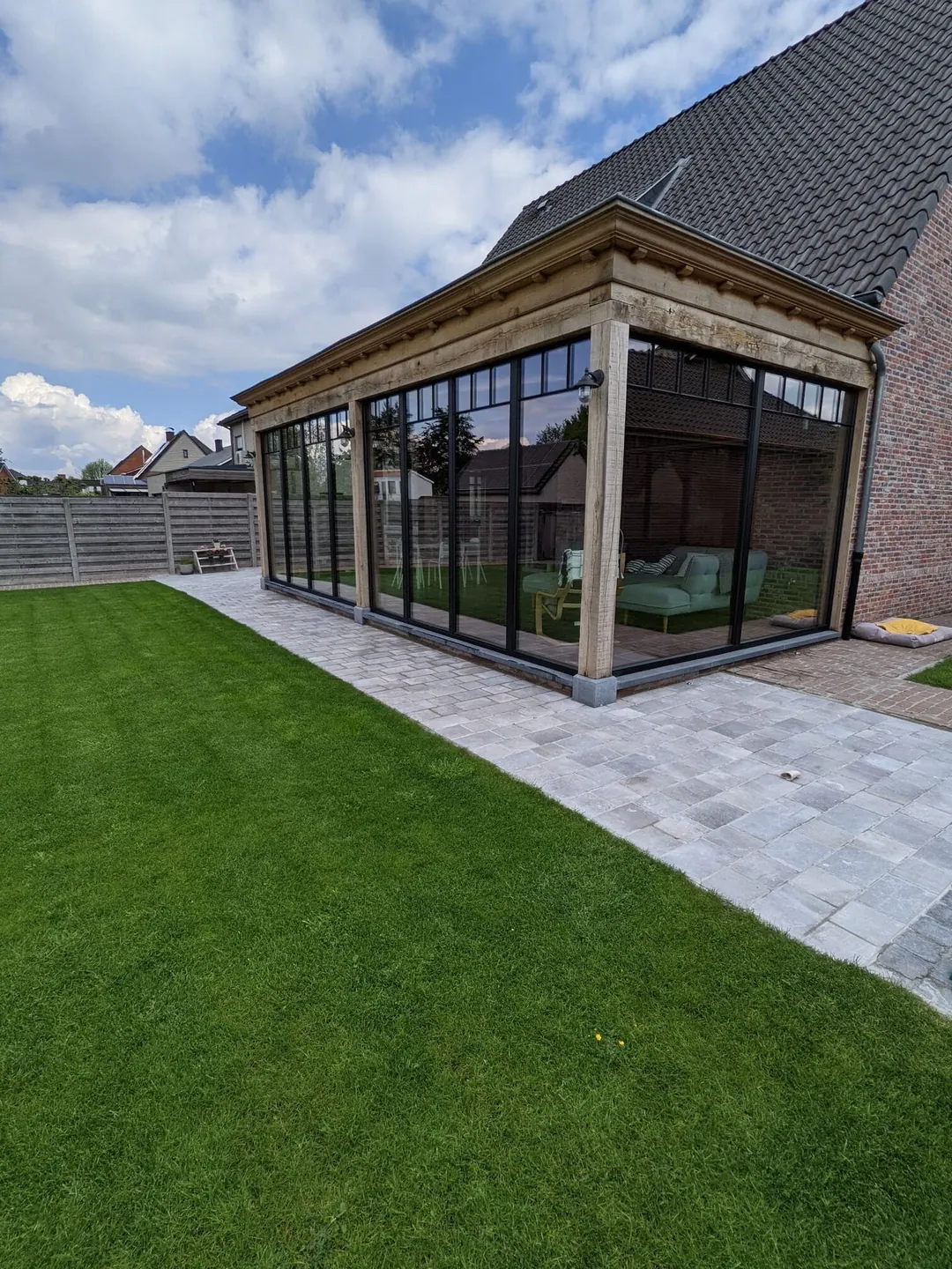 Glazen veranda met houten balken aan de tuin